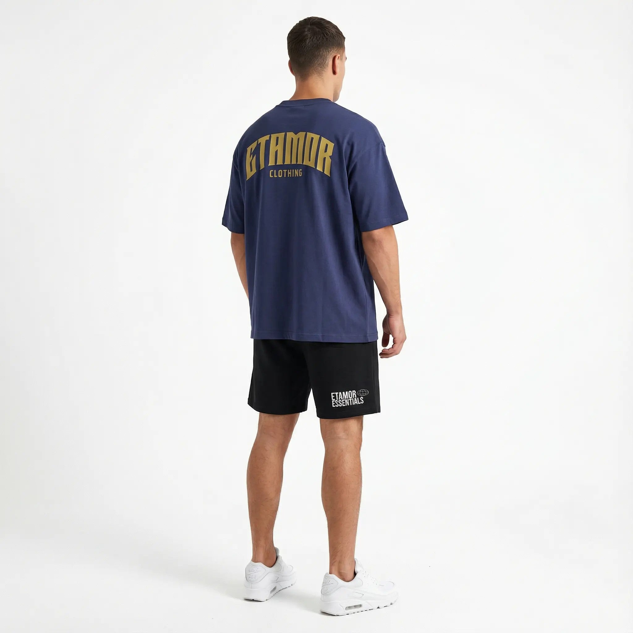 Person wearing a navy blue t-shirt and black shorts with 'STAMFORD CLOTHING' branding on a white background