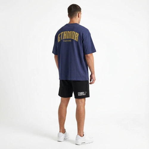 Person wearing a navy blue t-shirt and black shorts with 'STAMFORD CLOTHING' branding on a white background