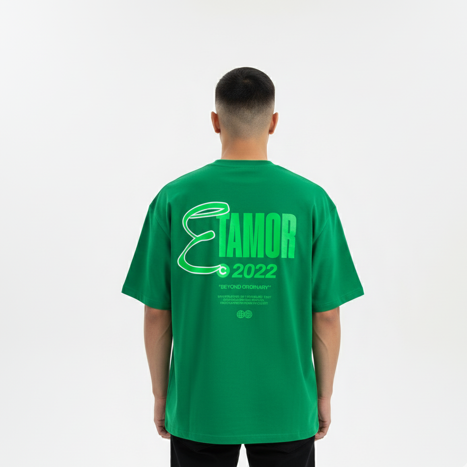 Person wearing a green t-shirt with 'Elamor 2022' text on the back against a white background