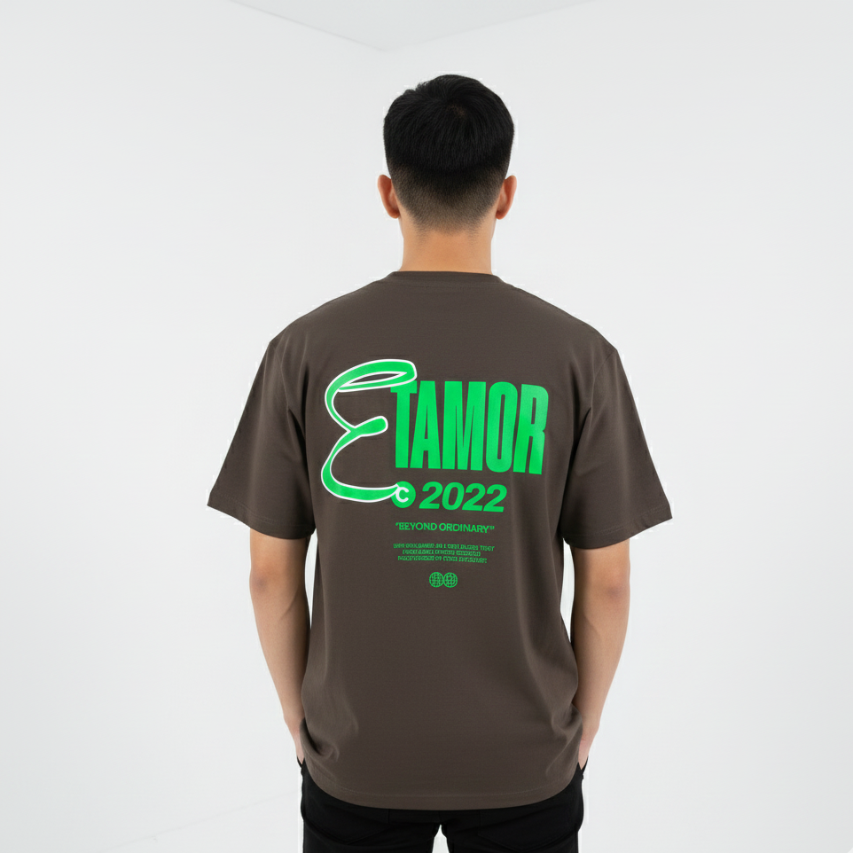 Person wearing a brown t-shirt with green text on the back against a white background