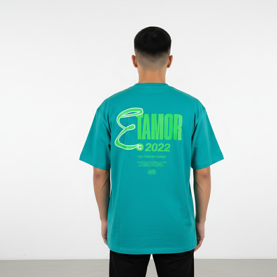 Person wearing a teal t-shirt with green text on the back against a white background