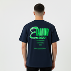 Person wearing a navy blue t-shirt with green text on the back, standing against a white background